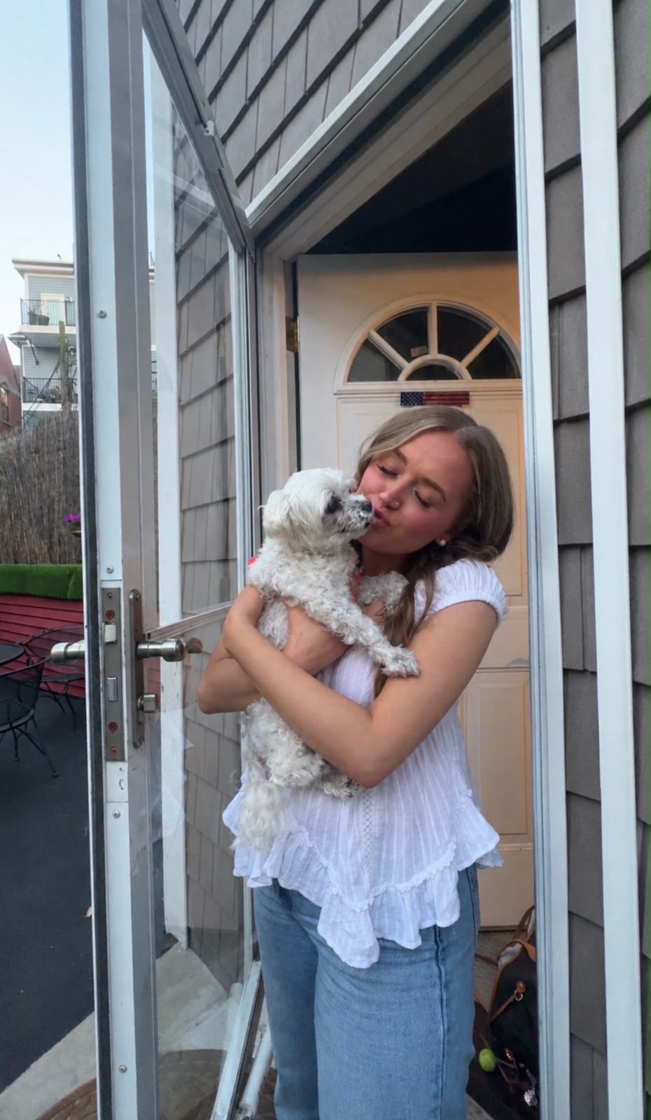 Boston's Groomer team member holding a small white dog